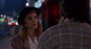 Movie still from “Short Circuit 2” (1988), directed by Kenneth Johnson – A woman wearing a black hat is talking to a man; Close Up shot, Over the shoulder angle