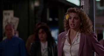 Movie still from “Short Circuit 2” (1988), directed by Kenneth Johnson – A woman with a yellow flower in her hair; Close Up shot, Over the shoulder angle