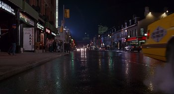 Movie still from “Short Circuit 2” (1988), directed by Kenneth Johnson – A city street at night lit by street lights; Extreme Wide shot, High angle