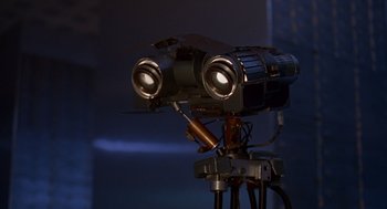 Movie still from “Short Circuit 2” (1988), directed by Kenneth Johnson – A video camera on top of a camera stand; Close Up shot, Low angle