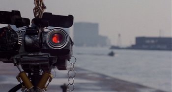 Movie still from “Short Circuit 2” (1988), directed by Kenneth Johnson – A red light on a camera; Extreme Close Up shot, Low angle