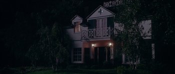 Movie still from “Short Cuts” (1993), directed by Robert Altman – A house that is lit up at night time; Extreme Wide shot, Low angle
