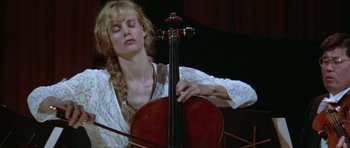 Movie still from “Short Cuts” (1993), directed by Robert Altman – A woman is playing a cello in front of a crowd; Close Up shot, Low angle