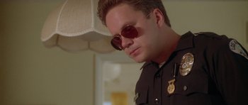 Movie still from “Short Cuts” (1993), directed by Robert Altman – A man wearing sunglasses and a police uniform; Close Up shot, Low angle