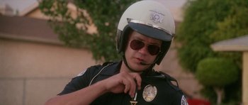 Movie still from “Short Cuts” (1993), directed by Robert Altman – A police officer putting on a helmet and sunglasses; Close Up shot, Low angle