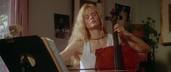 Movie still from “Short Cuts” (1993), directed by Robert Altman – A woman with long blonde hair is playing a cello; Close Up shot, Low angle