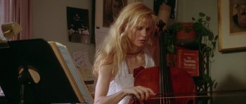 Movie still from “Short Cuts” (1993), directed by Robert Altman – A woman playing a cello in a room with paintings on the walls; Medium shot, Low angle