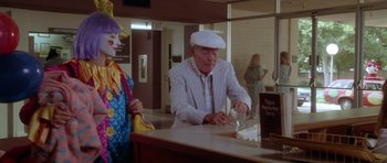 Movie still from “Short Cuts” (1993), directed by Robert Altman – An older man wearing a white hat and a white suit; Medium shot, High angle