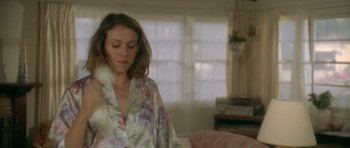 Movie still from “Short Cuts” (1993), directed by Robert Altman – A woman wearing a robe in a living room; Medium shot, Over the shoulder angle