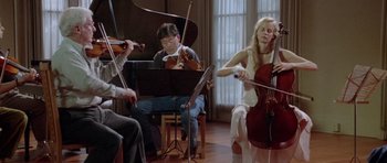 Movie still from “Short Cuts” (1993), directed by Robert Altman – A group of people sitting in a room playing musical instruments; Wide shot, Low angle