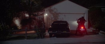 Movie still from “Short Cuts” (1993), directed by Robert Altman – A car parked in front of a garage at night; Extreme Wide shot, Low angle