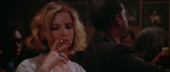 Movie still from “Short Cuts” (1993), directed by Robert Altman – A woman smoking a cigarette in front of a man; Close Up shot, Low angle