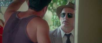 Movie still from “Short Cuts” (1993), directed by Robert Altman – A man wearing a hat and sunglasses talking to another man; Close Up shot, Over the shoulder angle