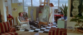 Movie still from “Short Cuts” (1993), directed by Robert Altman – A woman standing in front of a painting in a room; Wide shot, High angle
