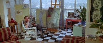 Movie still from “Short Cuts” (1993), directed by Robert Altman – A person sitting in front of an easel in a room; Wide shot, High angle