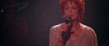 Movie still from “Short Cuts” (1993), directed by Robert Altman – A person holding a microphone; Close Up shot, Low angle