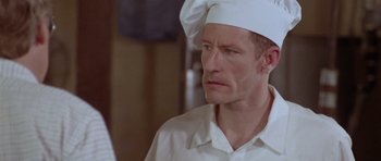 Movie still from “Short Cuts” (1993), directed by Robert Altman – A man wearing a chef's hat looking sad; Close Up shot, Low angle