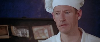 Movie still from “Short Cuts” (1993), directed by Robert Altman – A person wearing a chef's hat; Close Up shot, High angle