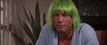 Movie still from “Short Cuts” (1993), directed by Robert Altman – A man with a green wig is sitting in a room; Close Up shot, Low angle