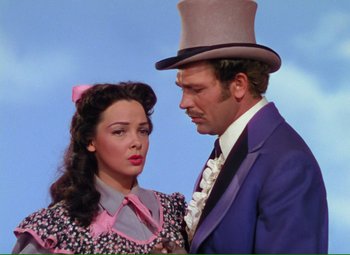 Movie still from “Show Boat” (1951), directed by George Sidney – A man and a woman standing next to each other in front of a sky background; Medium shot, Low angle