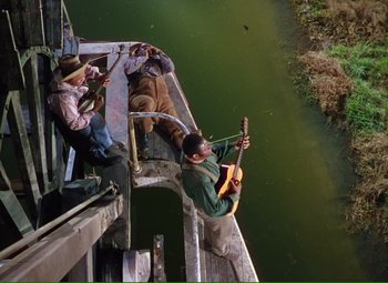 Movie still from “Show Boat” (1951), directed by George Sidney – A group of men playing instruments on a dock; Wide shot, High angle