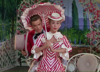 Movie still from “Show Boat” (1951), directed by George Sidney – A man and a woman dressed up in costumes and holding an umbrella; Medium shot, Low angle
