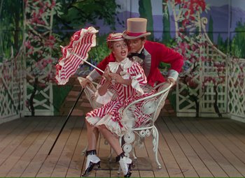 Movie still from “Show Boat” (1951), directed by George Sidney – A man and a woman dressed as a clown and a girl dressed as a clown; Wide shot, High angle