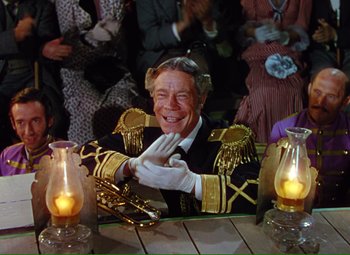 A man in a uniform sitting in front of candles