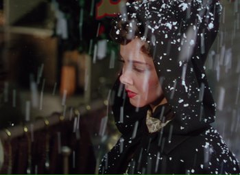 Movie still from “Show Boat” (1951), directed by George Sidney – A woman in a black coat is standing in the rain; Close Up shot, High angle