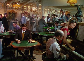 Movie still from “Show Boat” (1951), directed by George Sidney – A group of people sitting at tables playing cards; Wide shot, High angle