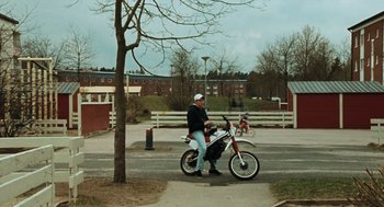 A man sitting on top of a bike on the side of a road