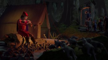 Movie still from “Shrek” (2001), directed by Vicky Jenson – An image of a man that is playing the flute; Wide shot, High angle