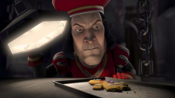 Movie still from “Shrek” (2001), directed by Vicky Jenson – A man with a knife in his hand looking at cookies on a tray; Close Up shot, High angle
