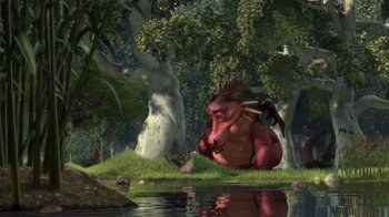 Movie still from “Shrek” (2001), directed by Vicky Jenson – A red dragon sitting in the grass next to a body of water; Extreme Wide shot, High angle