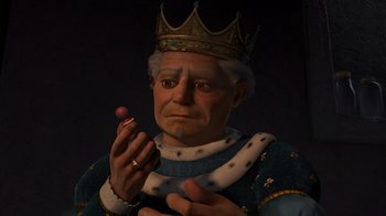 Movie still from “Shrek 2” (2004), directed by Andrew Adamson – An old man wearing a crown and holding a pink ball; Close Up shot, High angle