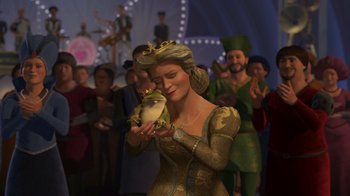 Movie still from “Shrek 2” (2004), directed by Andrew Adamson – A woman holding a frog in front of a crowd of people; Medium shot, Over the shoulder angle