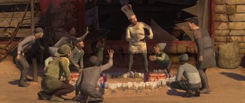 Movie still from “Shrek Forever After” (2010), directed by Mike Mitchell – A group of people standing in a circle around a statue of an elf; Wide shot, High angle