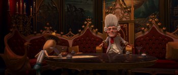 Movie still from “Shrek Forever After” (2010), directed by Mike Mitchell – A cartoon character is sitting at a table in front of two other characters; Wide shot, Over the shoulder angle
