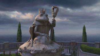 Movie still from “Shrek the Third” (2007), directed by Raman Hui – A statue of a frog holding a crown and holding a scepter; Wide shot, High angle