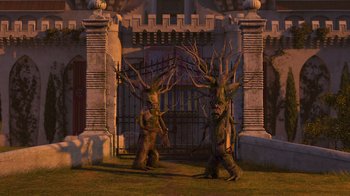 Movie still from “Shrek the Third” (2007), directed by Raman Hui – A couple of statues that are next to a gate; Wide shot, Low angle