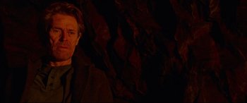 Movie still from “Siberia” (2020), directed by Abel Ferrara – A man standing in front of a rock wall at night; Close Up shot, Over the shoulder angle