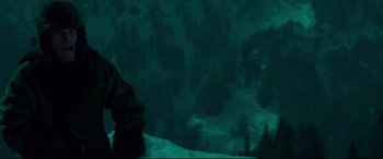 Movie still from “Siberia” (2020), directed by Abel Ferrara – A person standing on top of a snow covered slope; Medium shot, Low angle