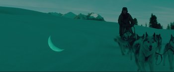 Movie still from “Siberia” (2020), directed by Abel Ferrara – A man riding a snowboard down the side of a snow covered slope; Wide shot, High angle