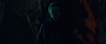 Movie still from “Siberia” (2020), directed by Abel Ferrara – A man standing in the dark in a dark room; Close Up shot, Low angle