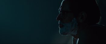 Movie still from “Siberia” (2020), directed by Abel Ferrara – An older man with a beard and glasses; Close Up shot, Over the shoulder angle