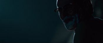 Movie still from “Siberia” (2020), directed by Abel Ferrara – An older man with glasses is looking at the camera; Close Up shot, Low angle