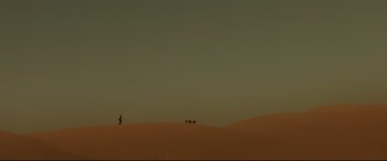 Movie still from “Siberia” (2020), directed by Abel Ferrara – A person standing on top of a sand dune with two dogs; Extreme Wide shot, Low angle