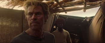 Movie still from “Siberia” (2020), directed by Abel Ferrara – Two men standing next to each other in front of a building; Close Up shot, Over the shoulder angle