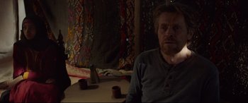 Movie still from “Siberia” (2020), directed by Abel Ferrara – A man sitting on a table in front of a mirror; Medium shot, Over the shoulder angle