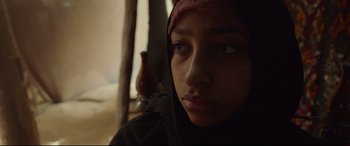 Movie still from “Siberia” (2020), directed by Abel Ferrara – A person with a bird in the background; Close Up shot, Over the shoulder angle